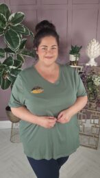 ONLY Lips T-Shirt in green with V-neckline, short sleeves and subtle lips detail, styled casually on a curvy model.