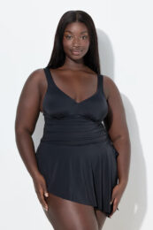 UllaPopken Asymmetrical Skirted Swimsuit in black with an asymmetrical skirt, decorative knot shoulder straps, soft cups, underbust band and built-in swimsuit bottoms.